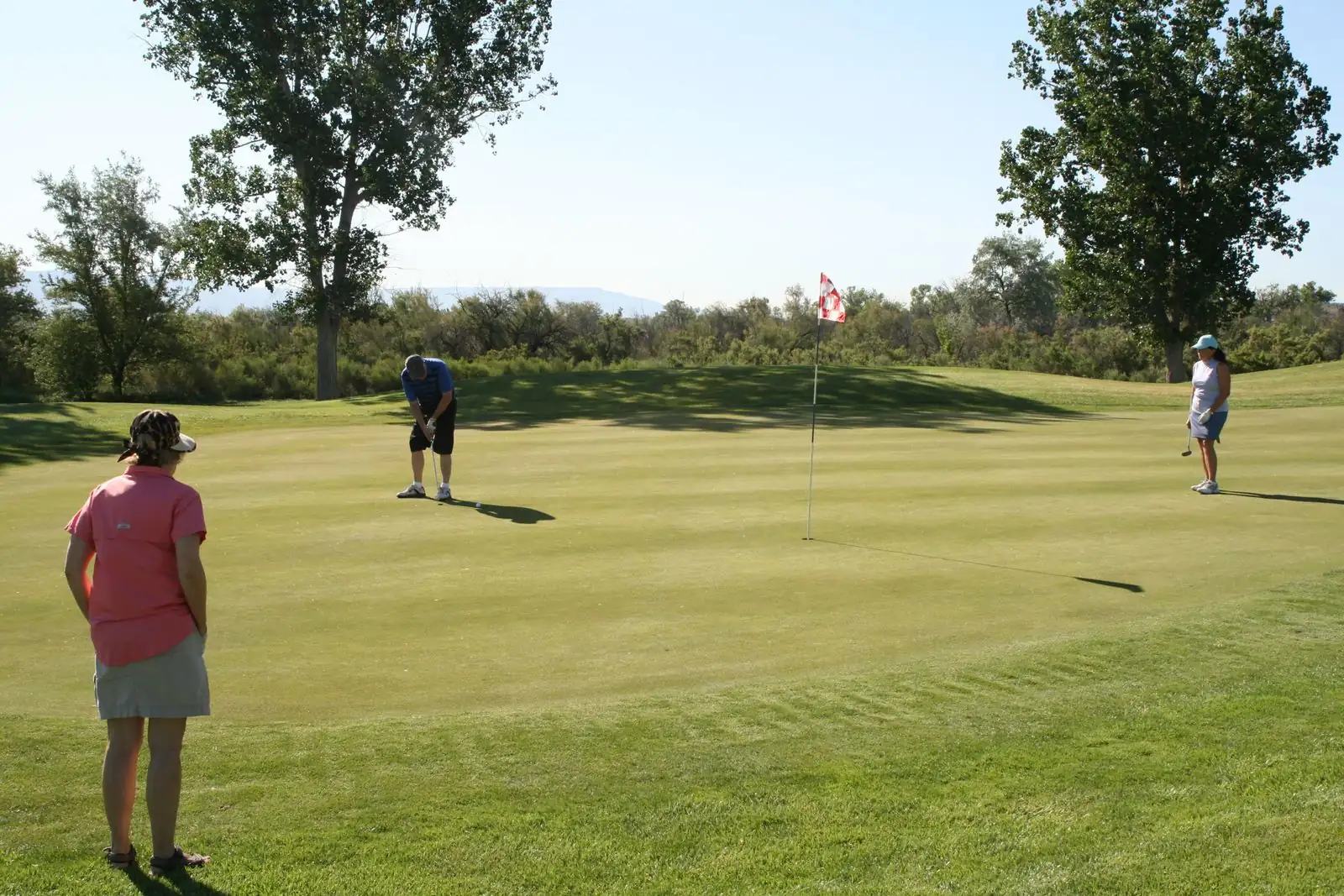 Golfer gạt bóng về phía cờ trên green
